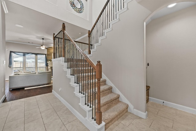 staircase featuring tile patterned floors and ceiling fan