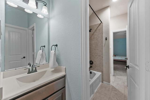 bathroom featuring vanity, tile patterned flooring, and tiled shower / bath