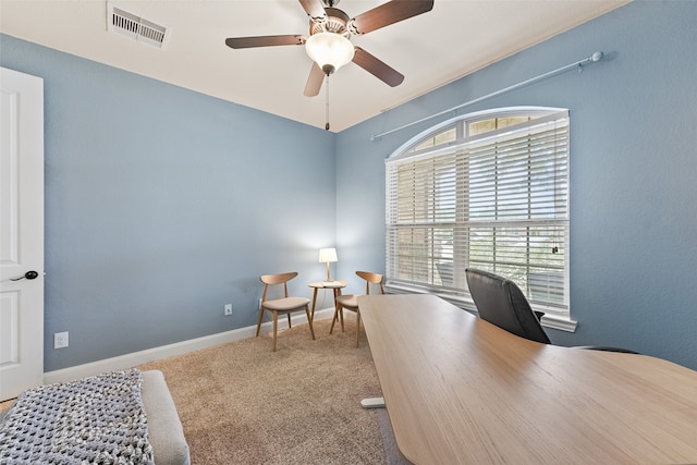 carpeted home office featuring ceiling fan