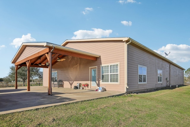 rear view of property featuring a patio, ceiling fan, and a lawn