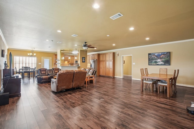 living room with ceiling fan with notable chandelier, crown molding, and dark hardwood / wood-style floors