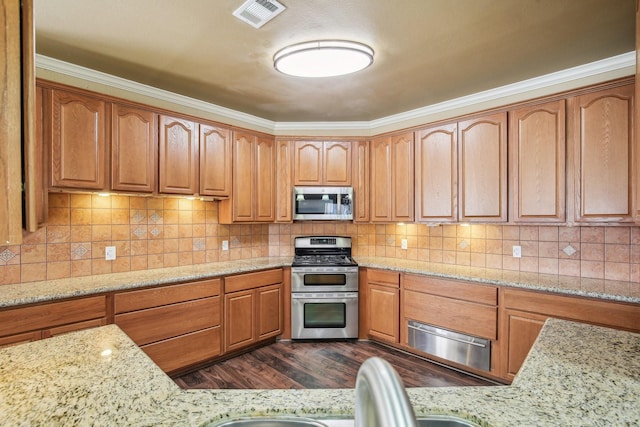 kitchen with stainless steel appliances, dark wood-type flooring, light stone countertops, and crown molding