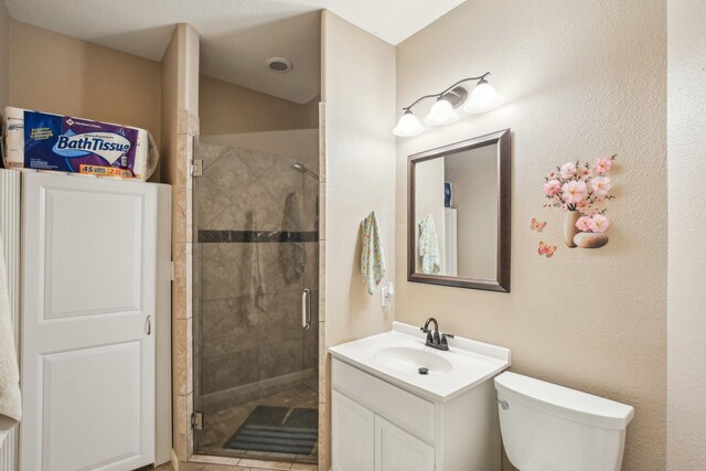 bathroom featuring toilet, an enclosed shower, and vanity