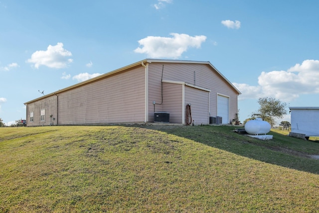 view of outbuilding featuring central AC and a lawn