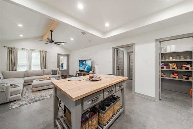 kitchen featuring butcher block countertops, a center island, concrete flooring, and vaulted ceiling with beams