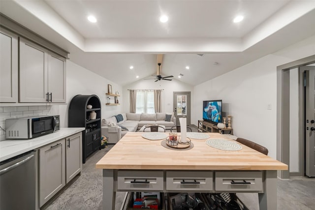 kitchen featuring ceiling fan, butcher block countertops, backsplash, gray cabinetry, and appliances with stainless steel finishes