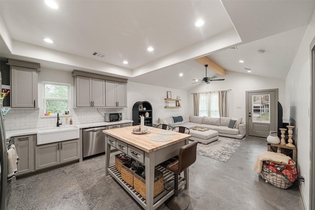 kitchen featuring sink, a healthy amount of sunlight, dishwasher, and concrete flooring