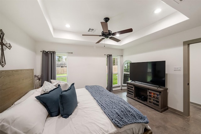 bedroom featuring a raised ceiling and ceiling fan