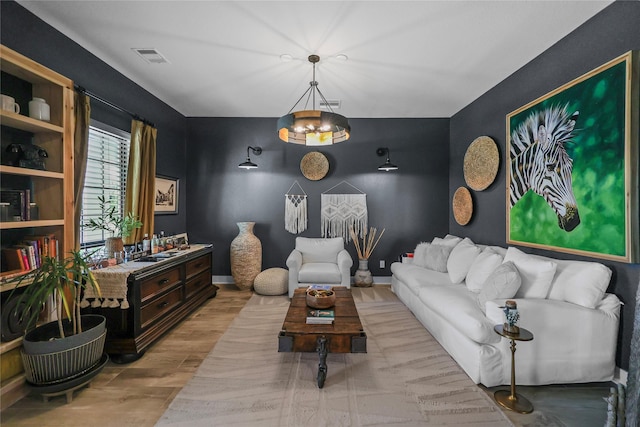 living room featuring a chandelier and light wood-type flooring