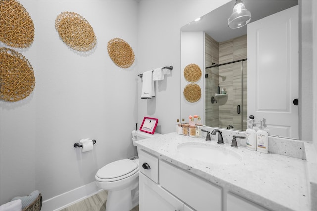 bathroom featuring toilet, walk in shower, and vanity