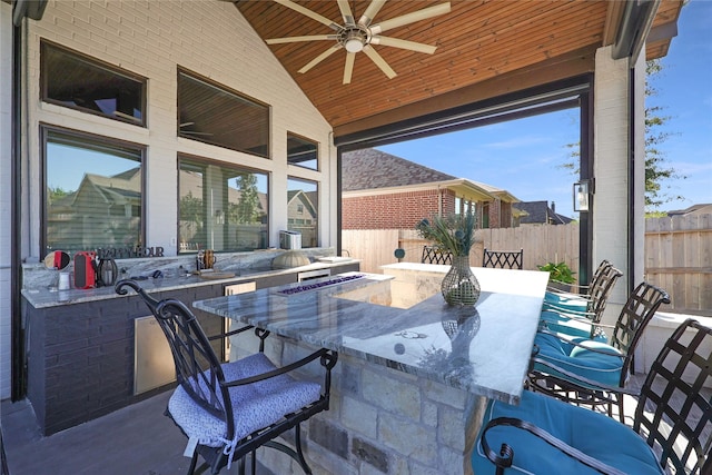 view of patio with ceiling fan and an outdoor bar