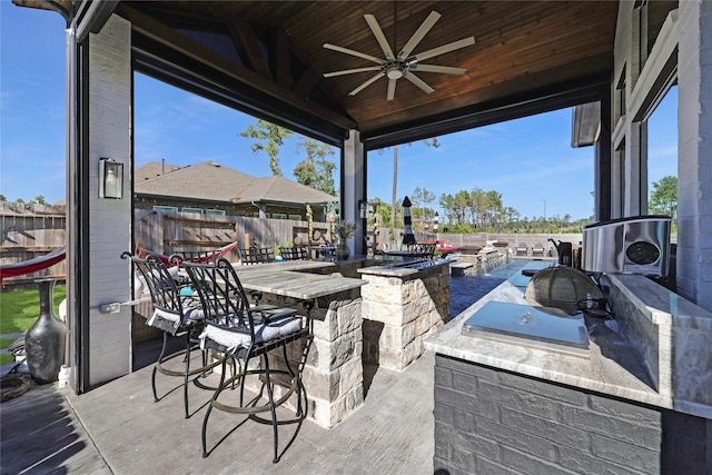 view of patio / terrace with a bar, area for grilling, and ceiling fan