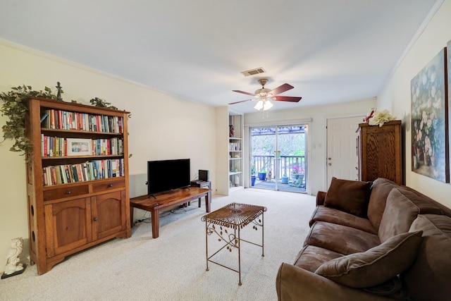 living room featuring ceiling fan, light colored carpet, and ornamental molding