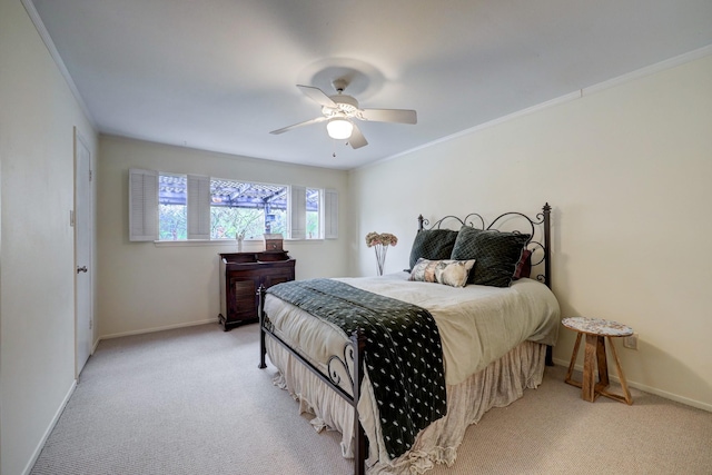 carpeted bedroom featuring ceiling fan and crown molding