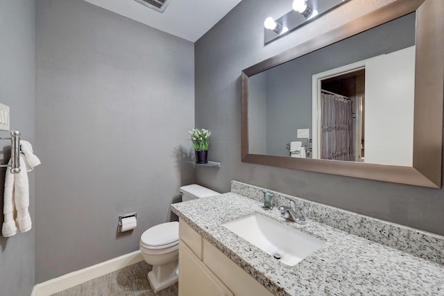 bathroom featuring toilet, vanity, and hardwood / wood-style flooring