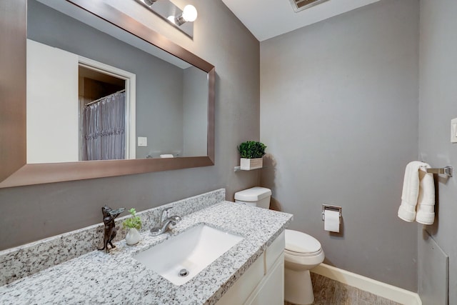 bathroom with toilet, wood-type flooring, and vanity