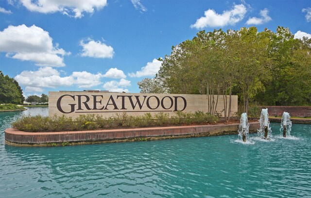 community / neighborhood sign with a water view