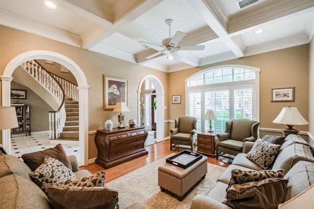 living room with beamed ceiling, coffered ceiling, and light hardwood / wood-style floors