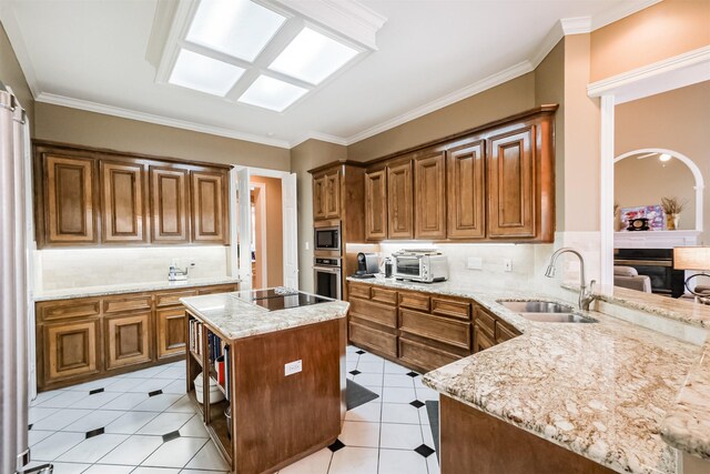 kitchen with light stone counters, sink, kitchen peninsula, and appliances with stainless steel finishes