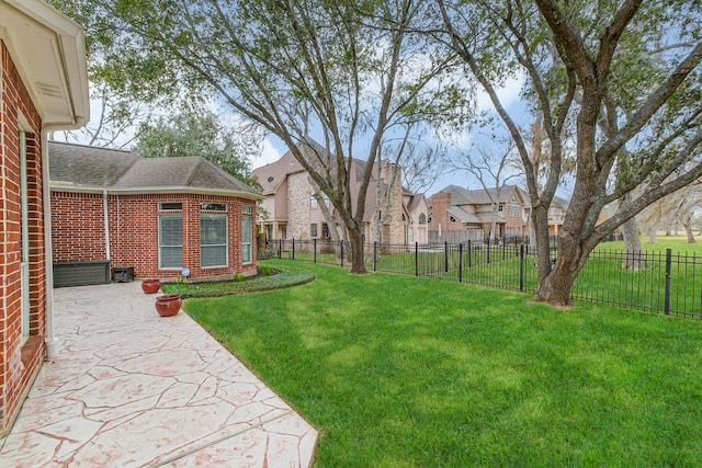 view of yard with a patio, a fenced backyard, and a residential view