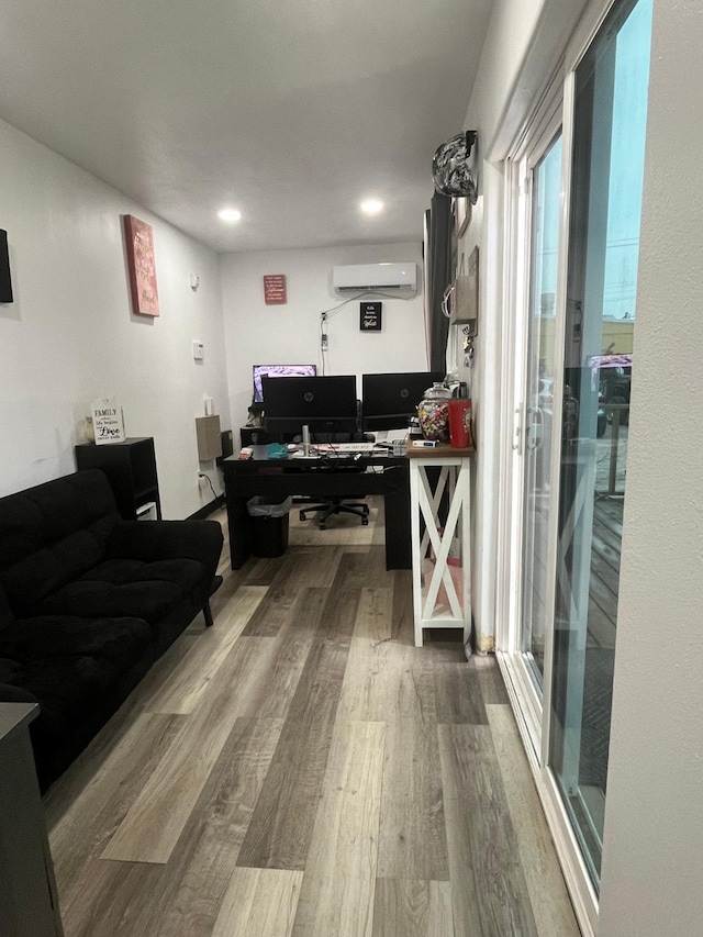 living room featuring hardwood / wood-style flooring and a wall unit AC