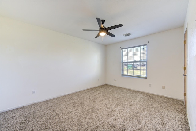 spare room featuring light colored carpet and ceiling fan