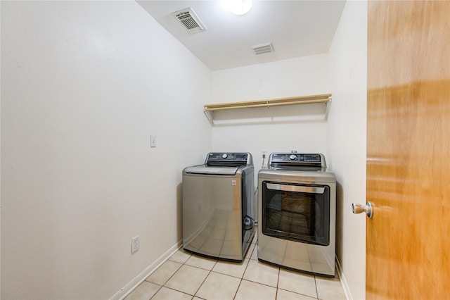 laundry area featuring separate washer and dryer and light tile patterned flooring