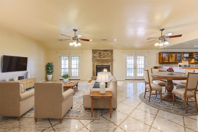 living room featuring french doors, a fireplace, and a healthy amount of sunlight