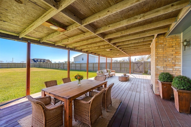 wooden terrace with an outdoor hangout area and a lawn