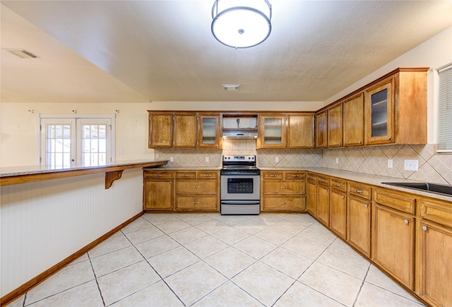 kitchen featuring sink, french doors, stainless steel range with electric stovetop, and light tile patterned floors