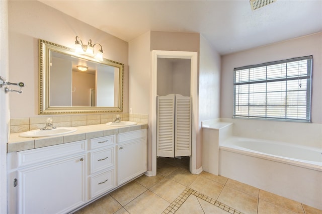 bathroom featuring vanity, tile patterned flooring, and a tub to relax in