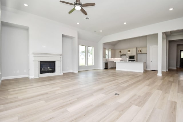 unfurnished living room featuring ceiling fan, light hardwood / wood-style floors, and lofted ceiling