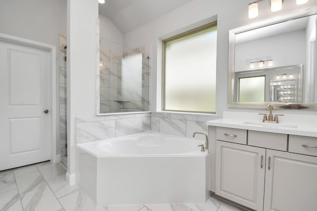 bathroom with vanity, vaulted ceiling, and a bath