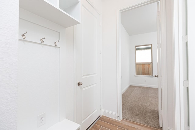 mudroom featuring wood finish floors and baseboards