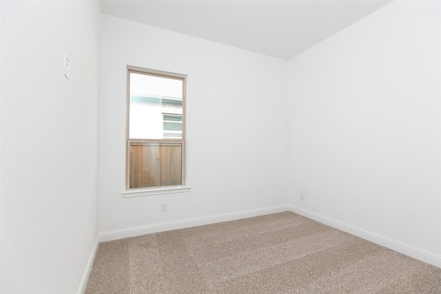 empty room featuring carpet and baseboards