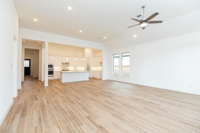 unfurnished living room with light wood finished floors, a sink, a ceiling fan, and recessed lighting