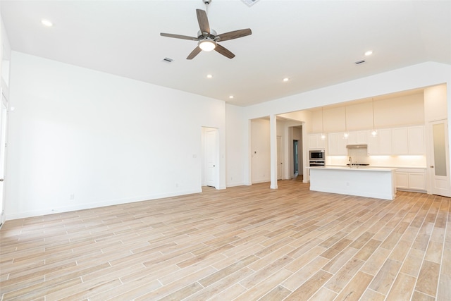 unfurnished living room with ceiling fan, light wood-style flooring, recessed lighting, visible vents, and baseboards