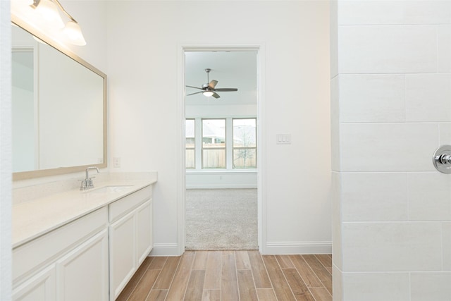 bathroom featuring wood finish floors, ceiling fan, vanity, and baseboards