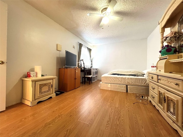 bedroom featuring a textured ceiling, ceiling fan, and hardwood / wood-style floors