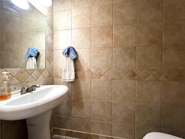 bathroom with tile walls and backsplash