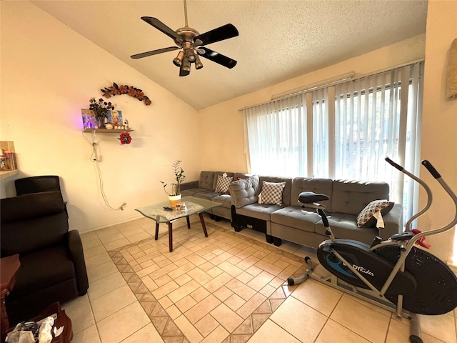 tiled living room with ceiling fan, vaulted ceiling, and a textured ceiling