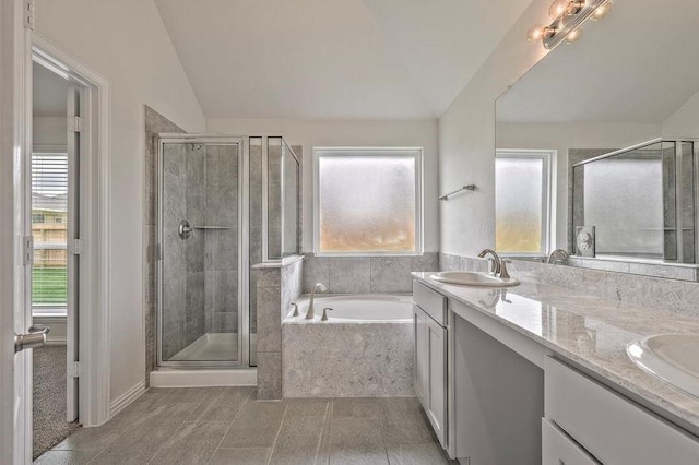 bathroom featuring lofted ceiling, tile patterned floors, independent shower and bath, and vanity