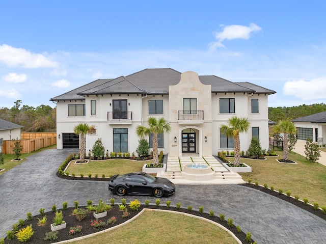 view of front of house with french doors, a front yard, and a balcony