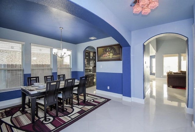 tiled dining area featuring a notable chandelier