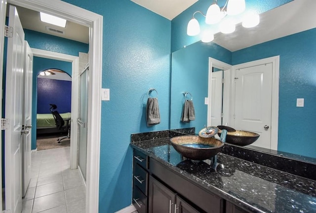 bathroom featuring a notable chandelier, tile patterned flooring, vanity, and a shower with shower door