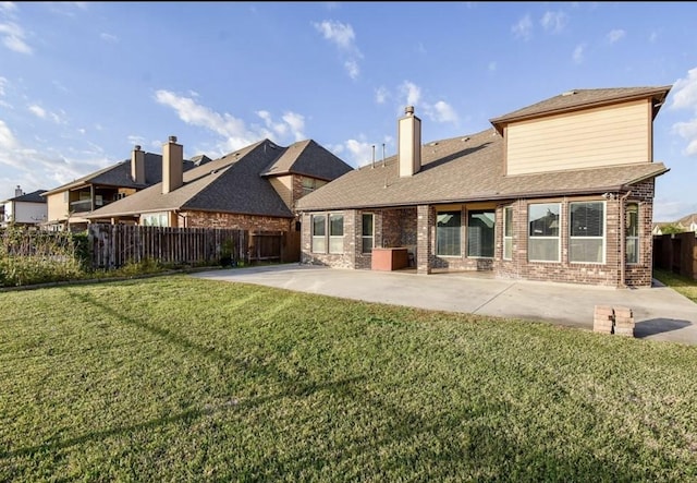 back of house with a lawn and a patio