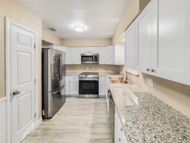 kitchen with sink, white cabinetry, and appliances with stainless steel finishes