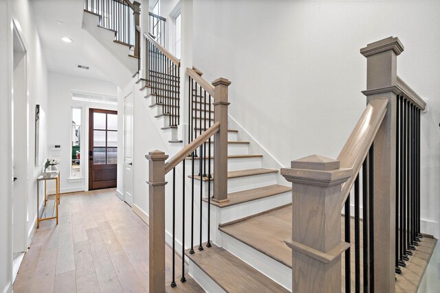 stairway featuring a high ceiling and hardwood / wood-style flooring