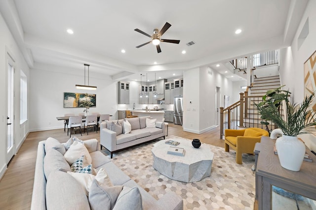 living room with ceiling fan and light wood-type flooring