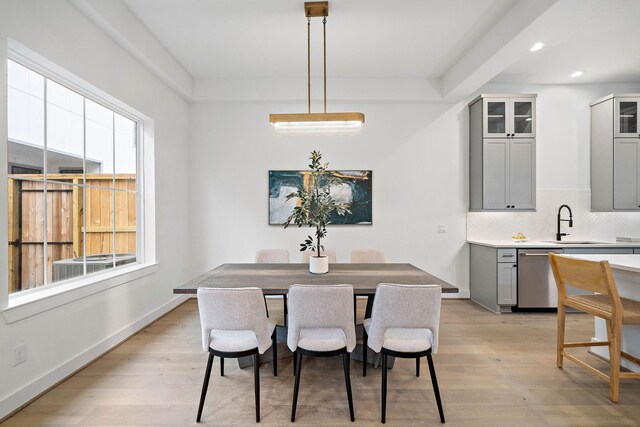 dining area featuring a healthy amount of sunlight, light hardwood / wood-style floors, and sink